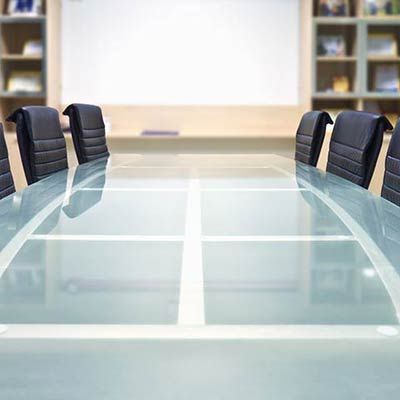 commercial-glass-conference-table Modern conference room with large glass table and black chairs designed by Westoaks Glass & Mirror.