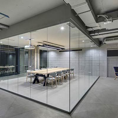 commercial-glass-partition-wall Contemporary office space with full glass partition walls and minimalist meeting area by Westoaks Glass & Mirror.