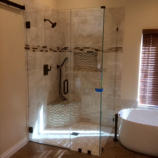 custom-frameless-glass-shower-with-accent-tile Custom frameless glass shower with accent tile and built-in bench installed by Westoaks Glass & Mirror.