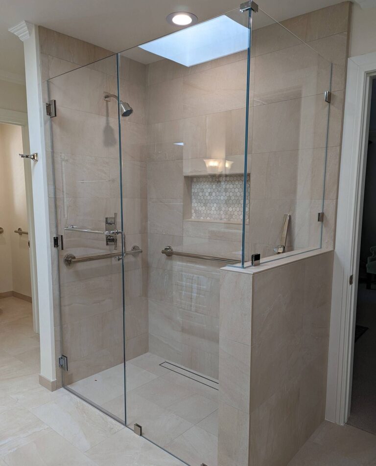frameless-glass-shower-with-handrails Elegant frameless glass shower with chrome hardware and built-in handrails installed by Westoaks Glass & Mirror.