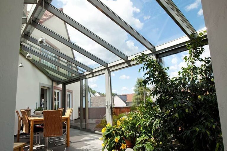residential-glass-skylight Residential sunroom with glass skylights and sliding doors allowing natural light into a cozy indoor garden.